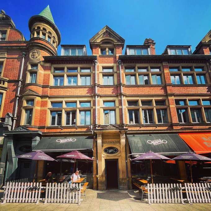 Sunny patio outside Oporto on call lane with umbrellas and picket fence 🌞🍺