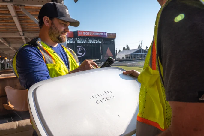 Photo of a man holding a large Cisco access point.