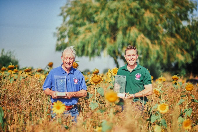 Previous award winners, Patrick and David Barker launch Suffolk’s Greenest County Awards in their field of winter bird food.