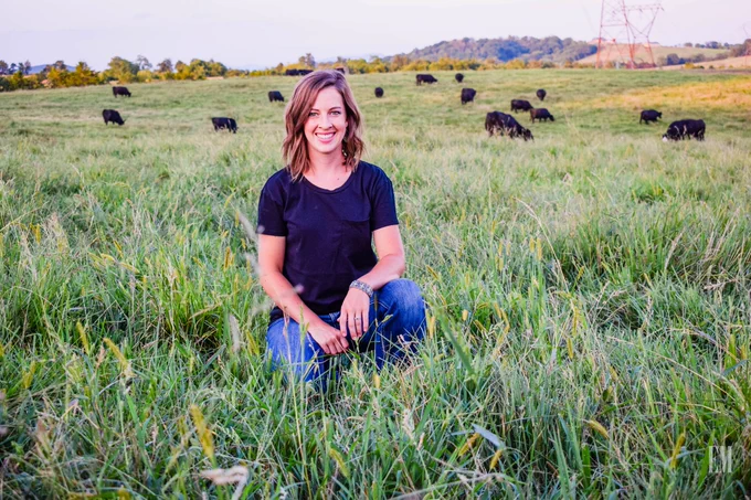 Elaine Martin in the pasture with beef cattle in the background