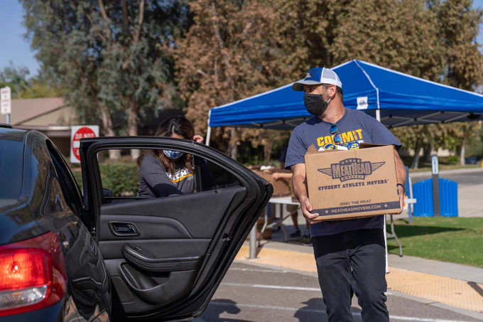 Man walking with box to a car. 