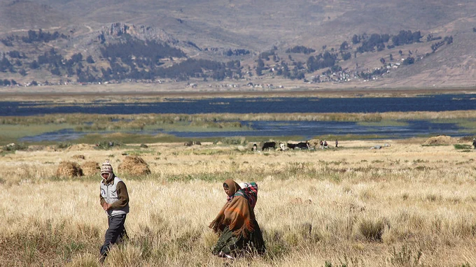 People walking across a rural landscape in Bolivia.