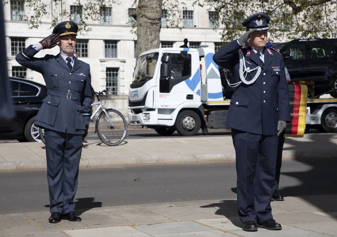 Image shows RAF German Air Force personnel saluting. 