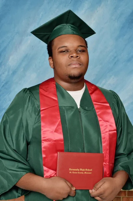 Image of Michael Brown Jr. holding up his diploma in a graduation photo.