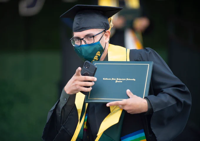 Male graduate looks at the camera after walking off the commencement stage. 