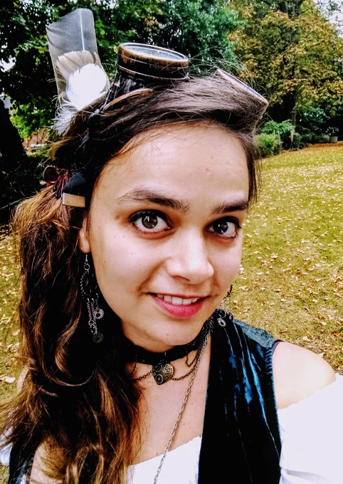 Shamini Bundell wearing goggles on her head, and standing in autumnal woodland.