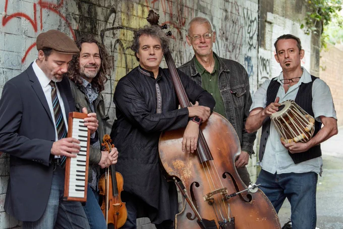 A portrait of Moishe's Bagel outside with their instruments.