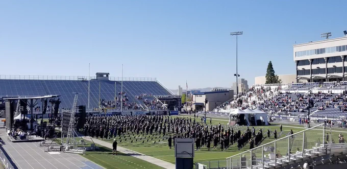 Hundreds of 2020 Graduates stand on the turf of Mackay Stadium for Spring Commencement 2021.