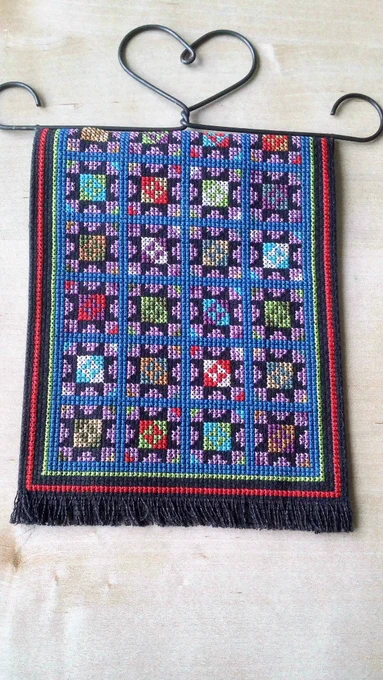 A brightly coloured cross-stitch blanket