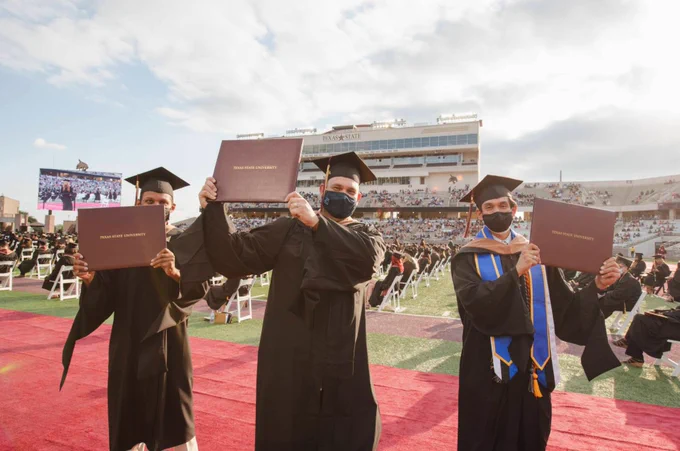 Texas State University Bobcat Stadium Spring 2021 Graduation Three Students with Diplomas