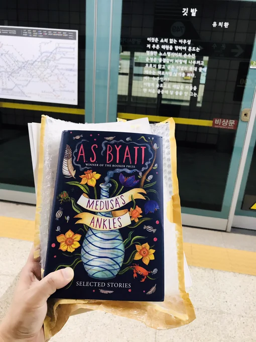 The cover of Medusa’s Ankles: Selected Stories by AS Byatt, against a backdrop of a Korean subway platform and a screen door with a Yu Chi-hwan poem stickered on it.