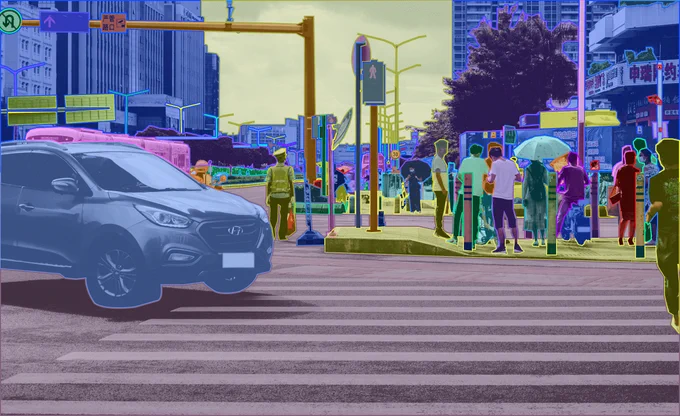 Pan-optic Segmentation of a road scene with cars, zebra crossing, traffic signals, road signs, pedestrians, and sidewalk.