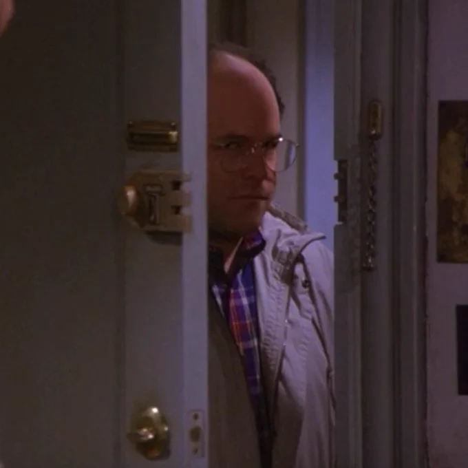 A still image from Seinfeld in which George Costanza is still staring at Kramer, who is just off-camera, judgmentally, while closing the door to the apartment.