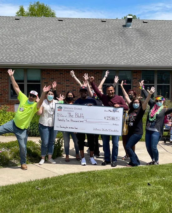 10 people gathered around a VU employee holding a giant check for $25,000
