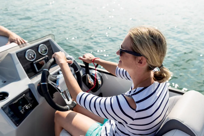 Woman driving a pontoon boat