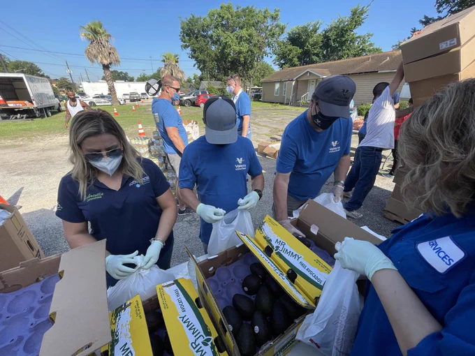 Employee volunteers bag avocados