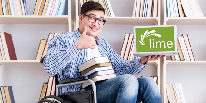 Young white man in library with glasses in wheelchair holding open laptop showing Lime Connect logo.  Books on lap