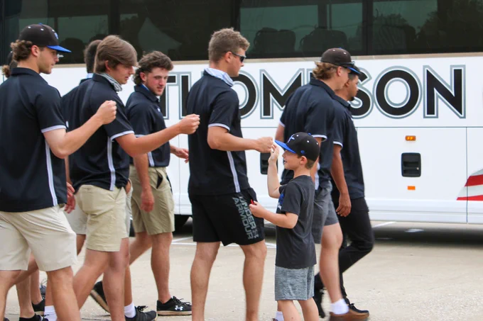 Young fan fist bumps players.