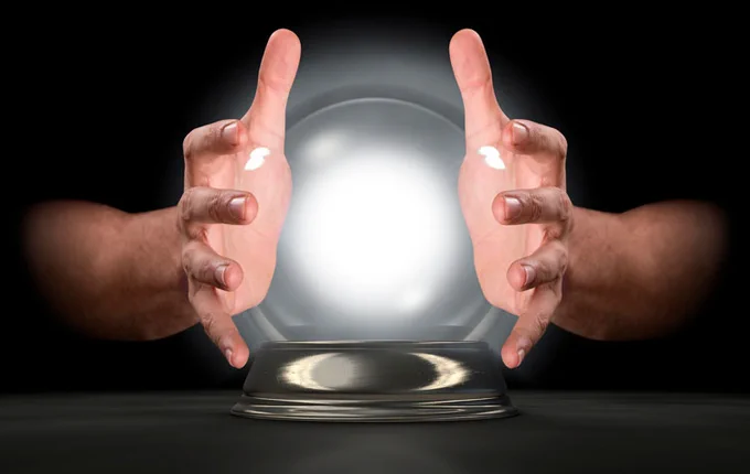 a glowing crystal ball with two hands held around it in front of a black background