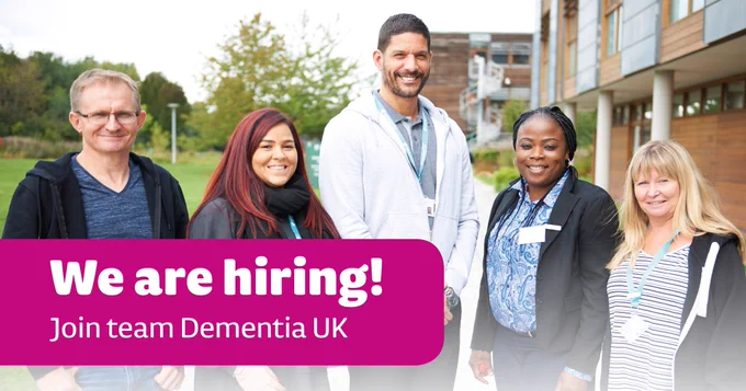 Five people stand smiling outside a building. A pink banner reads 'We are hiring! Join Team Dementia UK' in white text.