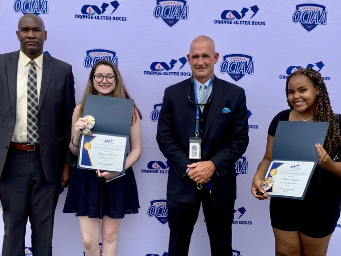 students and administrators pose for a picture following an award ceremony.