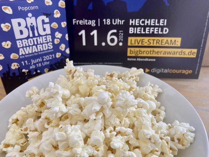 Schüsselchen mit Popcorn vor den Plakaten der BigBrotherAwards