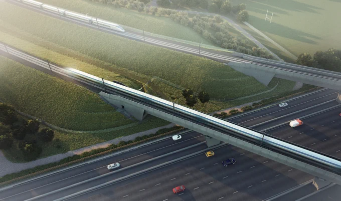 Two high speed trains cross viaducts over a motorway.