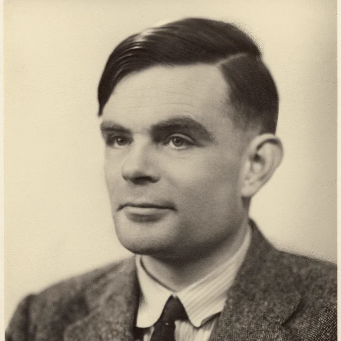 Black and white side on portrait photograph of Alan Turing in a suit looking away from the camera by Elliott & Fry