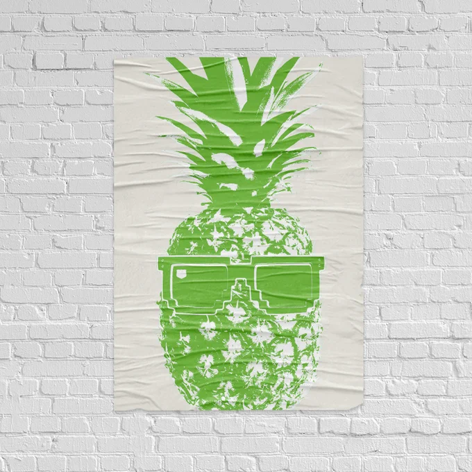 A posterized image of a lime green pineapple with sunglasses on a poster that's centered on a white brick wall.