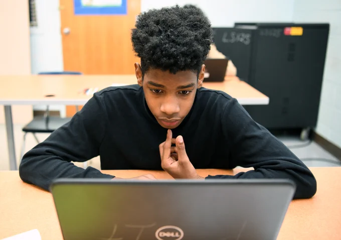 student looking at his laptop in class.