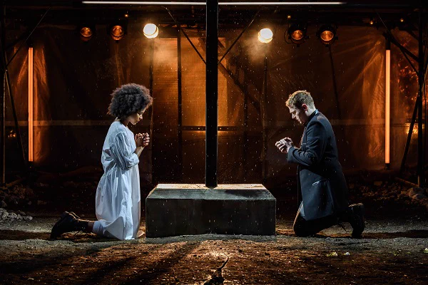 Romeo and Juliet kneeling down facing each other
