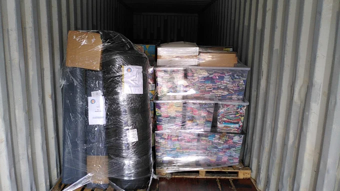 Two pallets of aid sit in a shipping container.