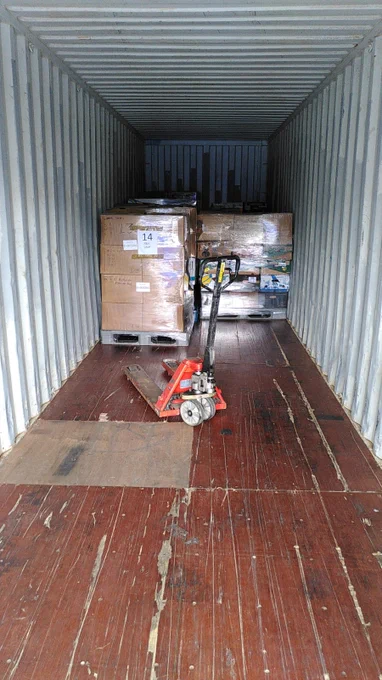 Two pallets of aid sit in a shipping container.