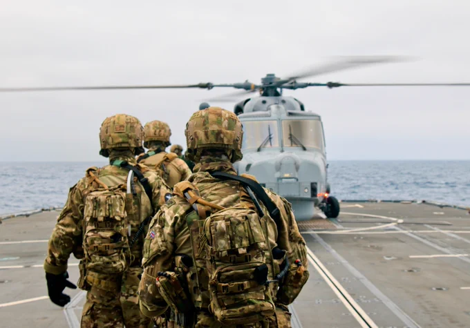 Royal Marines prepare for fast roping training with a Wildcat helicopter