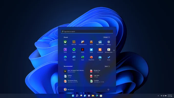 The new Windows 11 Start menu, located in the center of the taskbar. The background of the image is a blue bloom design on a dark colored background.