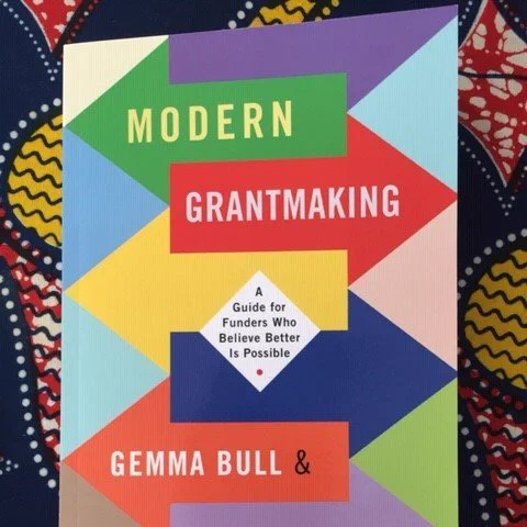 Photograph of the front cover of a brightly coloured book called Modern Grant Making - A guide for funders who believe better is possible