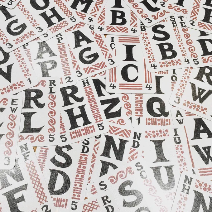 A whole bunch of cards at jaunty angles. 2 letters, in black, are on each card. There is a faint (reddish brown) suit/pattern around the border of each card.