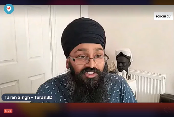 Screenshot of a livestream - Taran Singh, a Sikh man with a black beard and turban and a teal patterned top, in front of some VR equipment. 