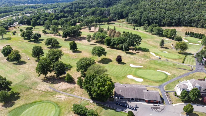 Aerial photo of Corning Country Club golf course on a summer day. View of holes 18, 8, 9, and 15 behind the club’s pro shop.