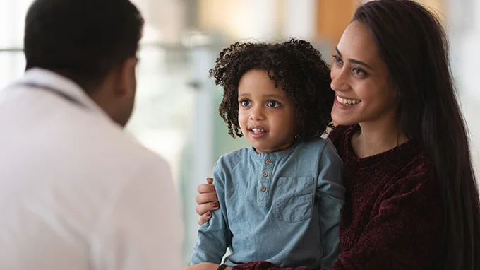 A mother and her child talk to their pediatrician. 