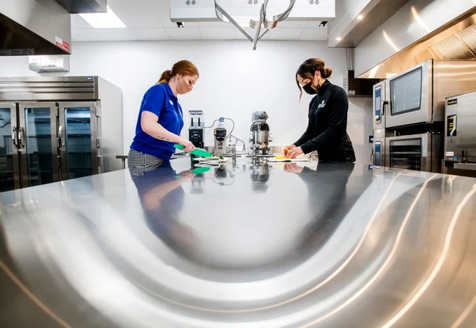 Grand Valley clinical dietetics students, Abigail Glonek, left, and Samantha Mann, right, work on June 1 in the dietetics kitchen in the new Daniel and Pamella DeVos Center for Interprofessional Health on GVSU's Health Campus.