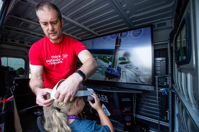 A man works to secure a virtual reality headset to a child's head
