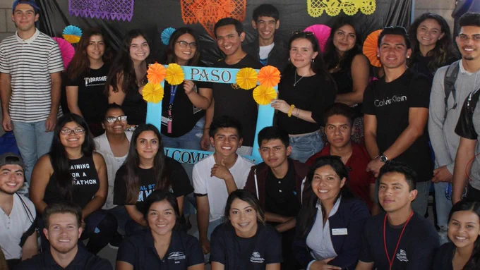 A group of smiling college students holding up a sign that reads P A S O.