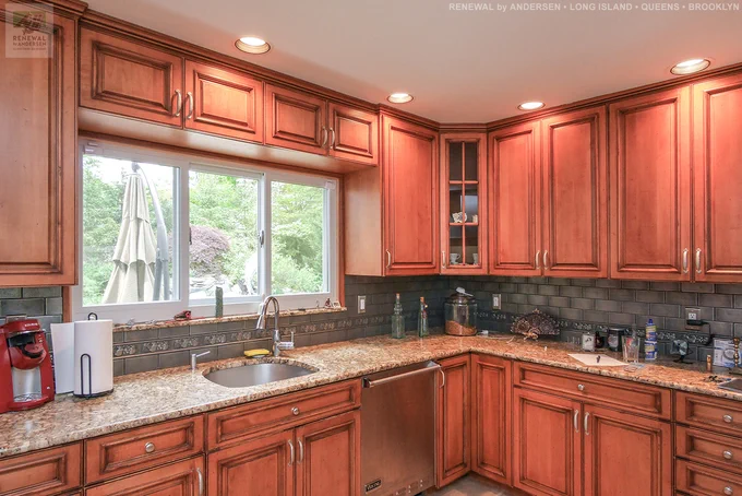 Triple gliding window we installed in this fantastic kitchen. This beautiful kitchen with wood cabinets and dark grey back splash looks wonderful with the new sliding window that looks out onto a stunning backyard pool. Find out more about getting new windows in your home from Renewal by Andersen of Long Island, serving Suffolk County, Nassau County, Queens and Brooklyn.