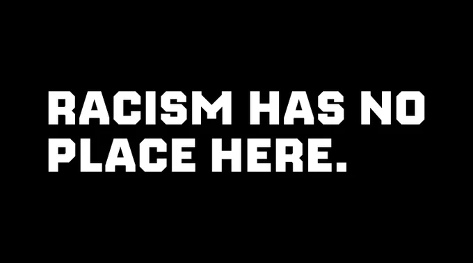 Black graphic with white text that says: "Racism has no place here" 