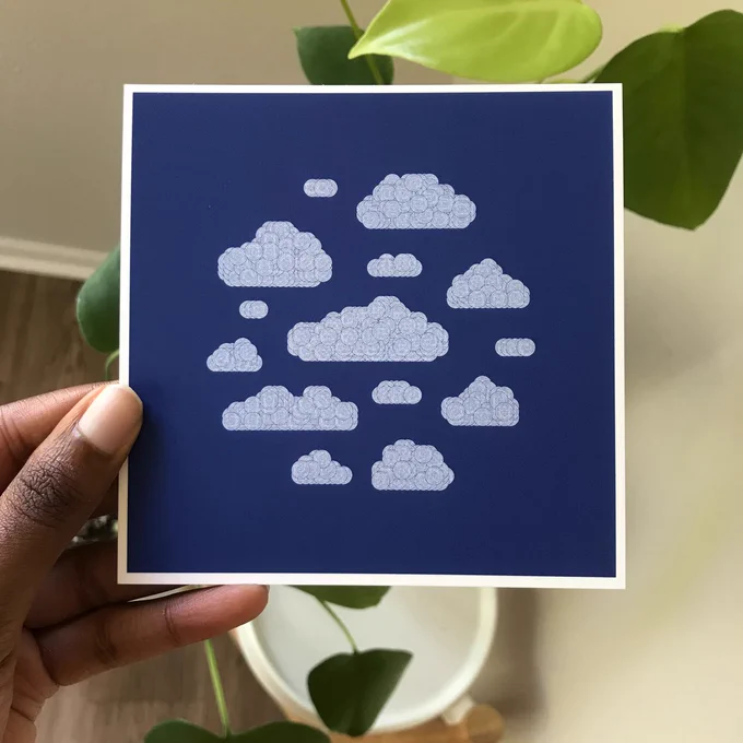 A picture of me holding a print in front of a backdrop of plants. The print is clouds created from concentric white circles.