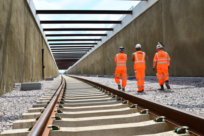 Engineers walk next to the newly installed track inside one of the entry and exit ramps to the tunnel.