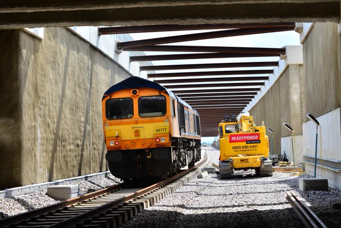 The very first locomotive to run through the new tunnel at Werrington emerges from the tunnel into daylight.
