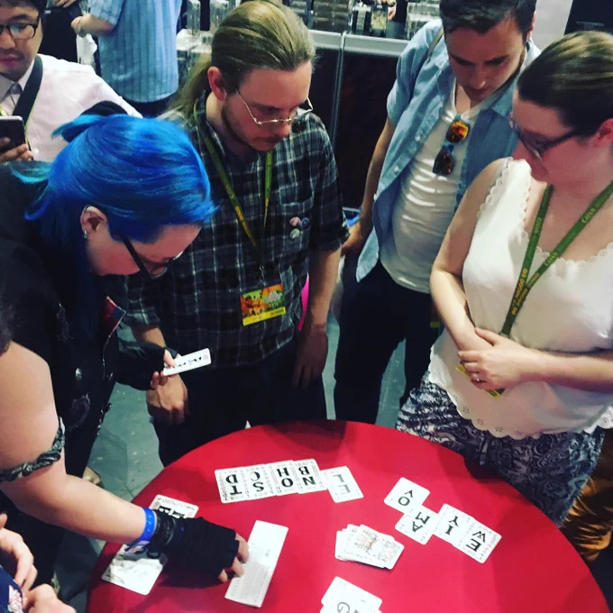 A few people engrossed in some sort of wordgame. There seem to be 3 people playing and 2 people watching. 