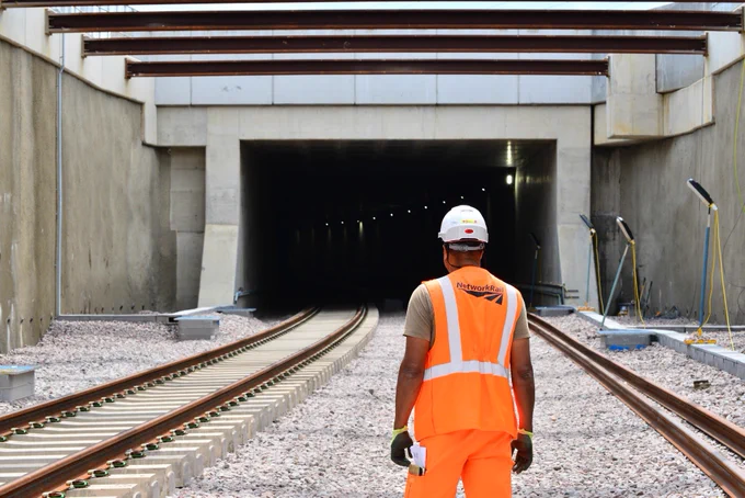 An engineer with their back to the camera stands in front of the new railway tunnel at Werrington.